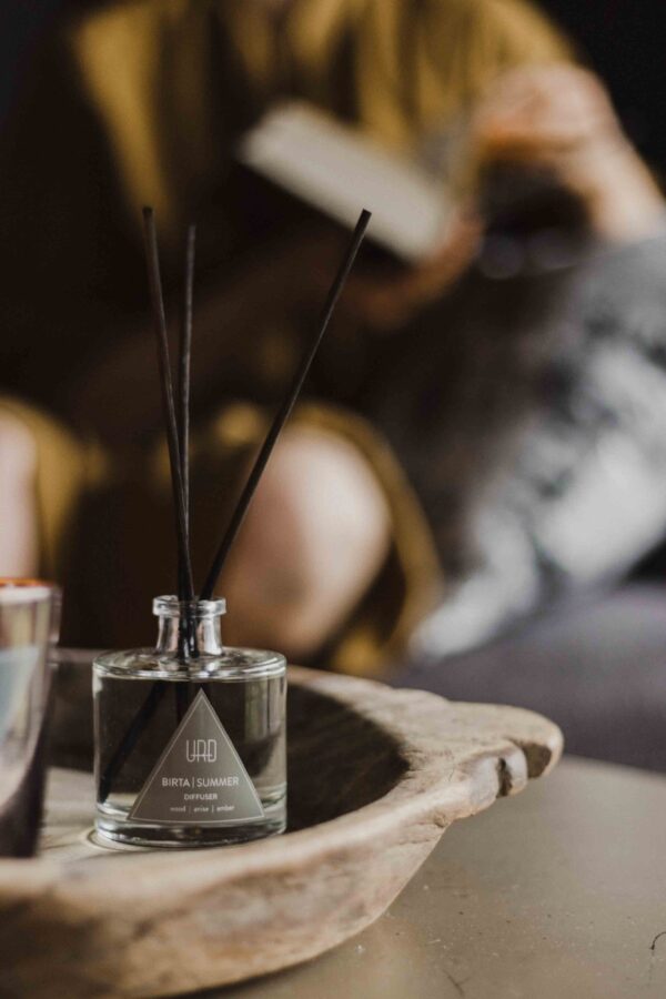 URÐ BIRTA home diffuser with black rattan sticks and a summer-inspired scent of wood, anise, and amber.